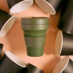 mikonsupply collapsible silicone cup among black paper cups, promoting eco-friendly, zero waste living.